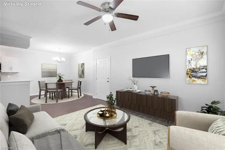 Living room with ornamental molding and ceiling fan with notable chandelier