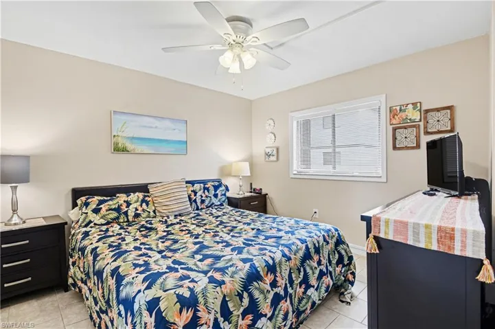 Bedroom with light tile patterned floors and ceiling fan