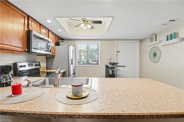 Kitchen with light countertops, stainless steel appliances, a ceiling fan, a peninsula, and recessed lighting