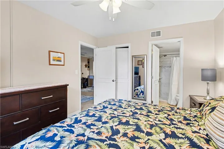 Bedroom featuring ceiling fan, ensuite bathroom, and a closet