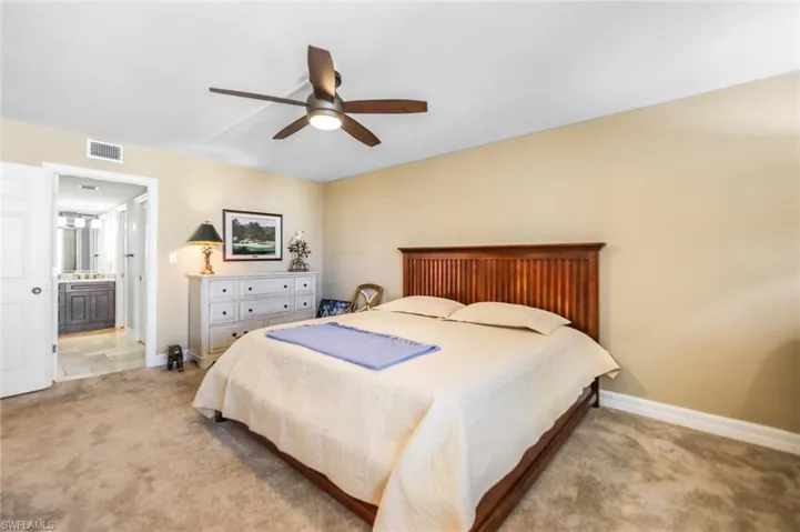 Bedroom with carpet, connected bathroom, and a ceiling fan