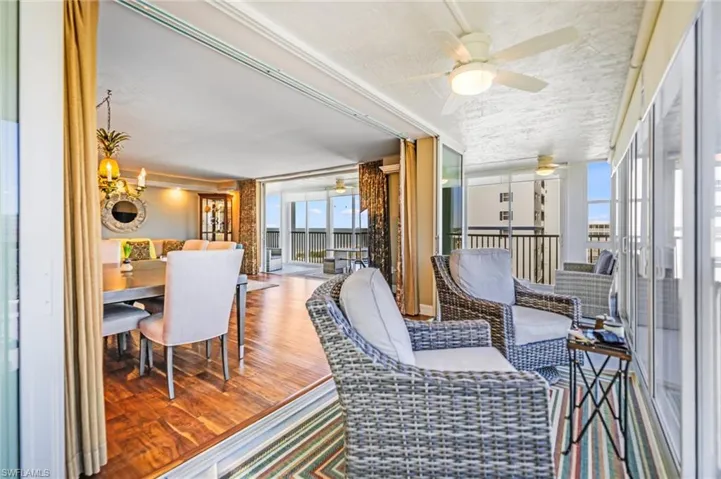 Sunroom / solarium with ceiling fan and a balcony