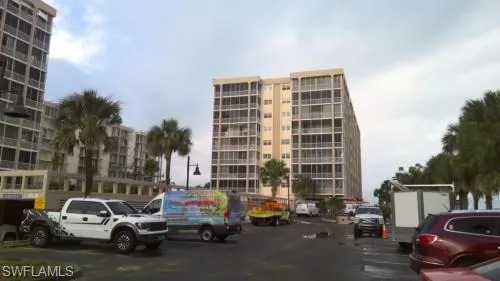 View of apartment building / complex with uncovered parking