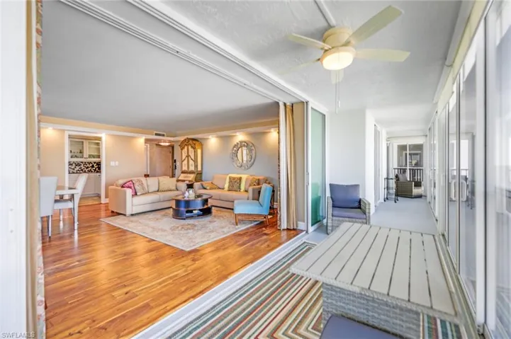 Living room with wood finished floors, a ceiling fan, and a textured ceiling