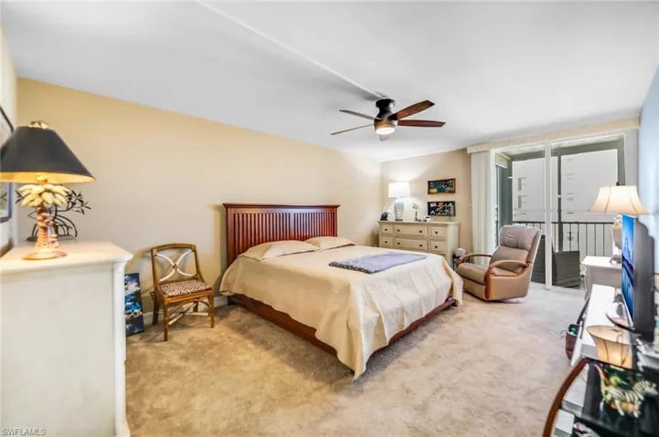 Carpeted bedroom featuring ceiling fan and access to exterior