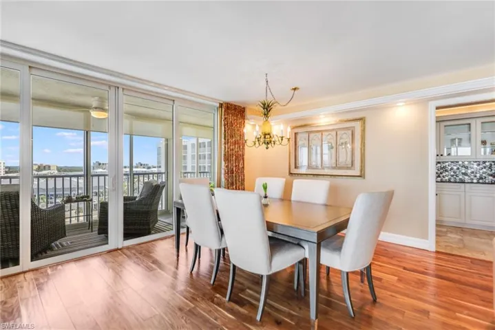 Dining area with light wood-style flooring and suspended lighting