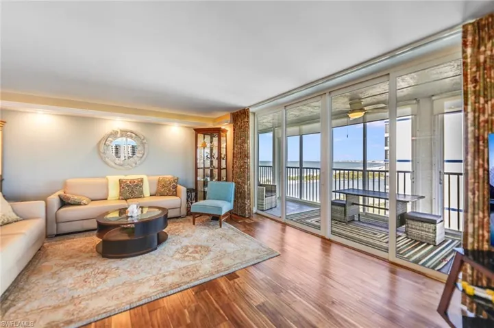 Living area with wood finished floors, floor to ceiling windows, and ceiling fan