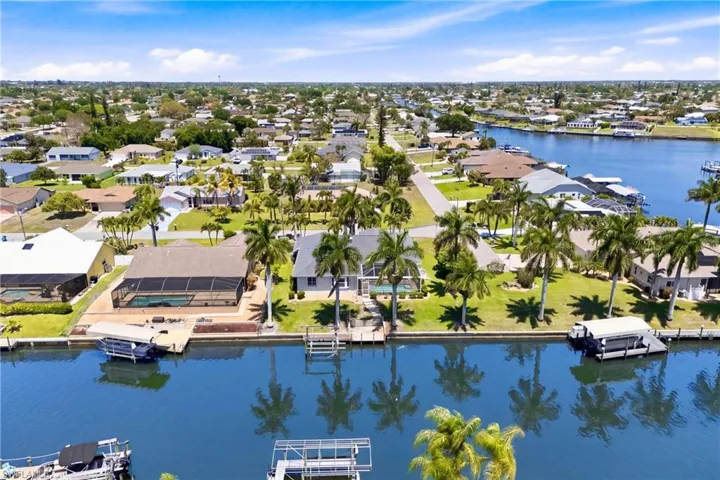This property offers direct canal access with a boat lift, a private dock, and a screened-in swimming pool