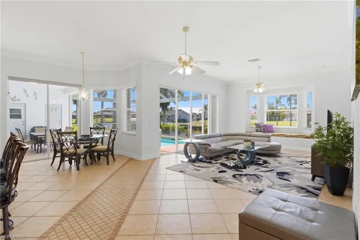 The property features an open-concept living area with tiled flooring, large windows, and ceiling fans