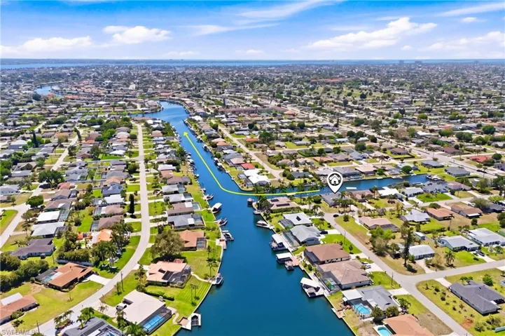 Aerial view showcasing the property's location within a canal-front community, with surrounding residential properties and waterways