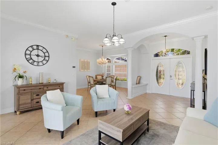 The property features a bright living area with tile flooring, crown molding, and an arched entry, enhancing the spacious feel