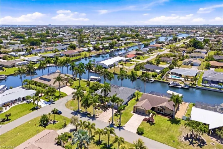 Aerial view showcasing the community with extensive waterways, mature palm trees, and residential properties