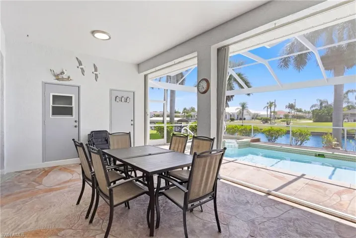 The property features a screened patio with a patterned floor, offering views of the pool and canal