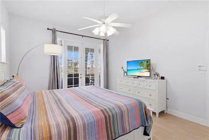 The property features French doors with external views, a ceiling fan, and light-toned flooring