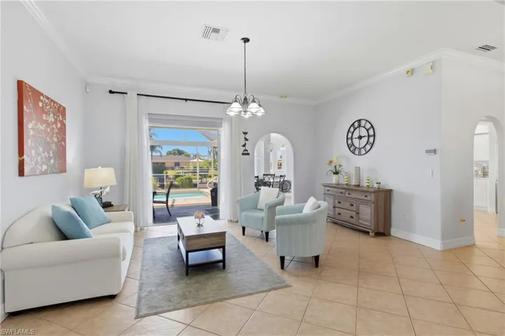 The living area features tile flooring, crown molding, and an arched doorway