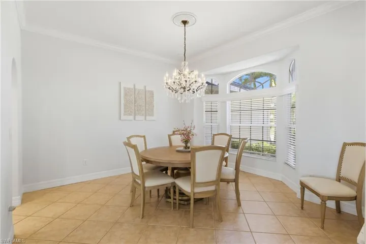 The dining area features light tile flooring, a bay window, and a chandelier