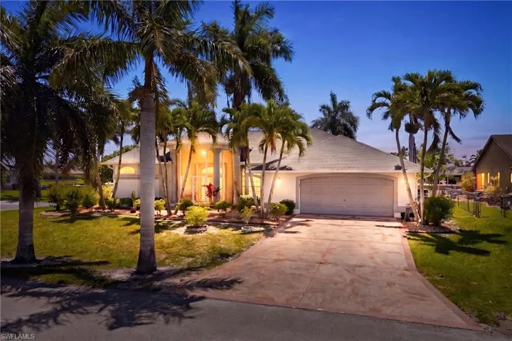 The property features a well-maintained exterior with a white facade, a two-car garage, and an inviting driveway