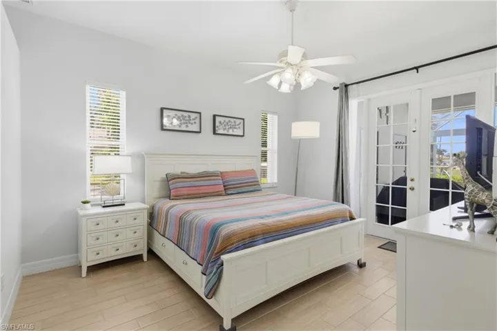 This room features light-colored flooring, white walls, and a ceiling fan