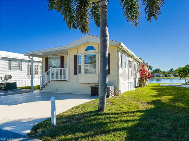 Manufactured / mobile home featuring a front lawn and a porch