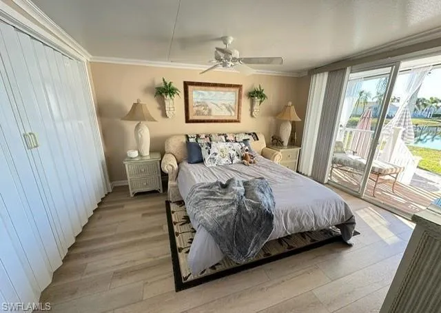 Bedroom featuring access to outside, wood finished floors, a ceiling fan, and ornamental molding