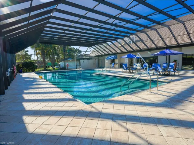 Community pool featuring glass enclosure and a patio