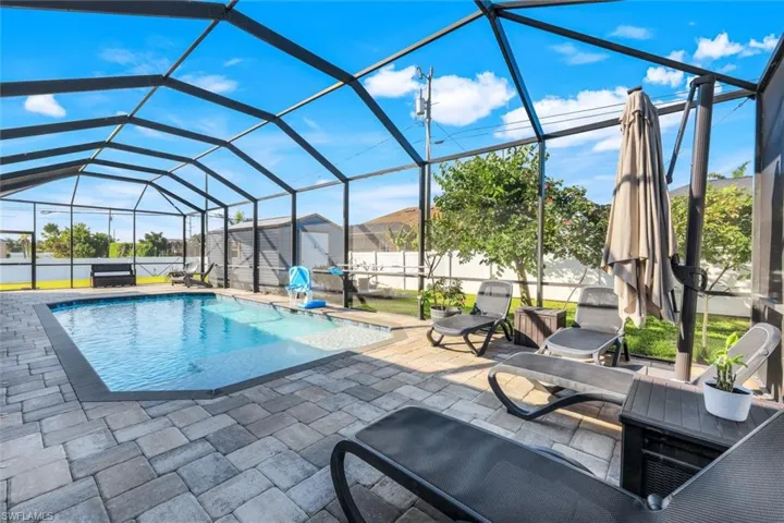 View of pool featuring a lanai, swim ledge, and a patio seating