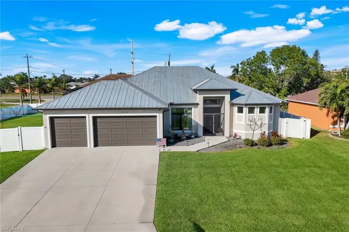 Front of home with long driveway and 3-car garage