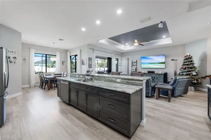 Kitchen with counter seating, granite countertops, GE matte slate appliance suite, overlooking dining area and great room