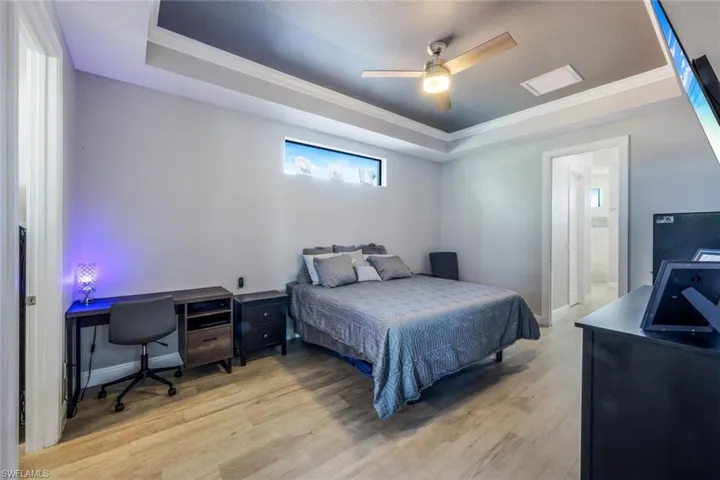 Primary bedroom features ensuite bathroom, crown molding, and a tray ceiling