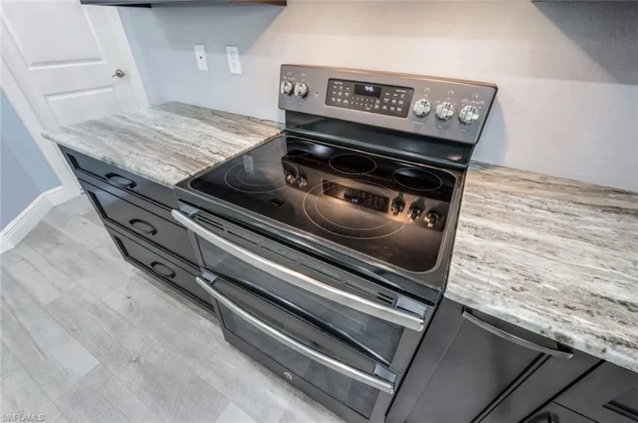 Kitchen with granite countertops, and double oven range from GE matte slate appliance suite.