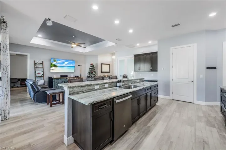 Open kitchen with counter seating, granite countertops, GE matte slate appliance suite.