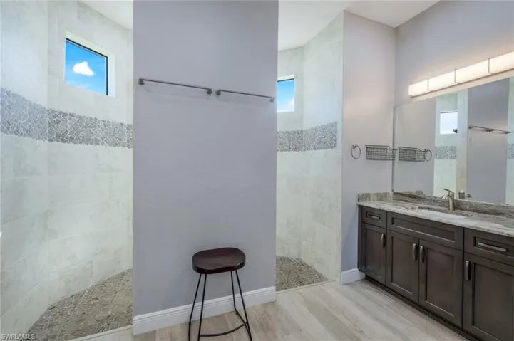 Bathroom with open dual-head shower and dual vanity