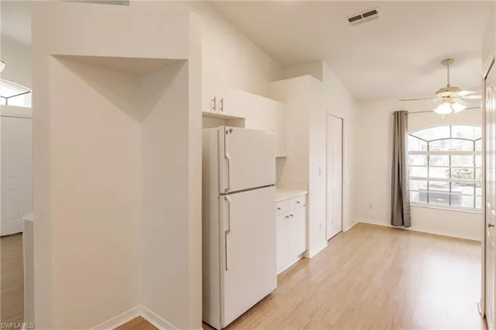 Kitchen with light hardwood / wood-style floors, a healthy amount of sunlight, and white fridge