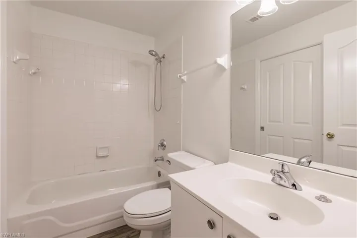 Full bathroom featuring oversized vanity, toilet, and tiled shower / bath combo