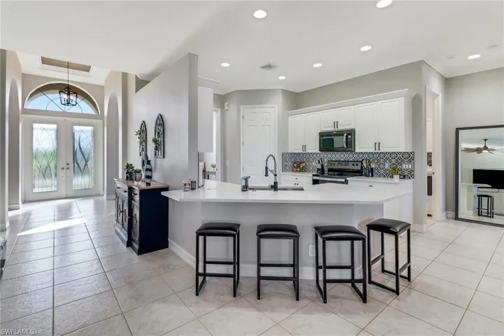 Quartz countertops, large pantry and newer stainless appliances, door to the left accesses the laundry room and 2.5 car garage