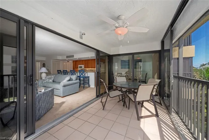 Sunroom / solarium featuring ceiling fan, outdoor dining area, and a balcony