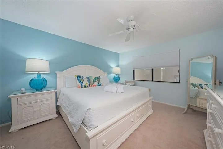 Bedroom featuring ceiling fan, light colored carpet, and a textured ceiling