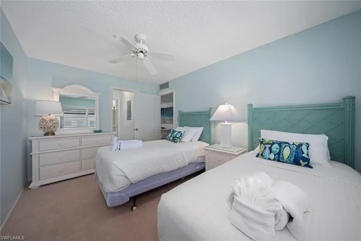 Bedroom featuring carpet, a textured ceiling, and a ceiling fan