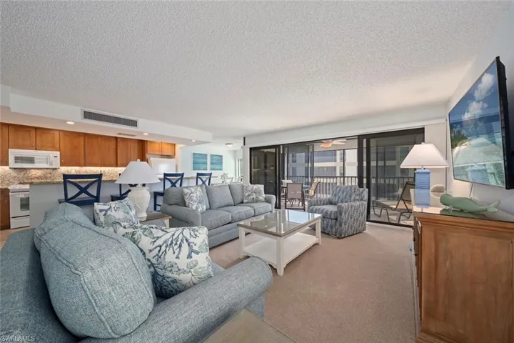 Living room with light carpet, a textured ceiling, and a ceiling fan