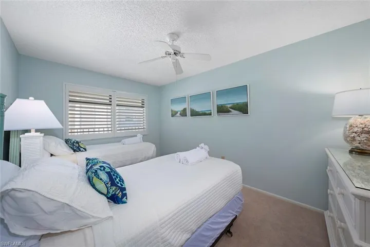 Carpeted bedroom with a textured ceiling and a ceiling fan