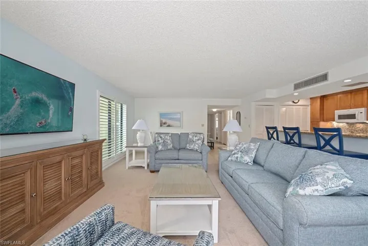 Living room with a textured ceiling and light carpet