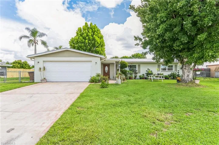 Single story home featuring a garage and a front yard