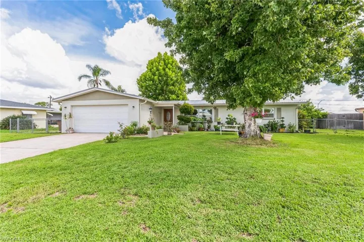 Ranch-style house featuring a garage and a front yard