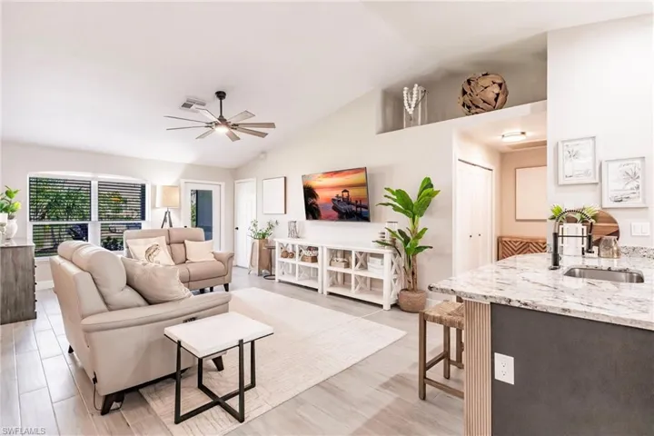 Living room featuring a ceiling fan and vaulted ceiling