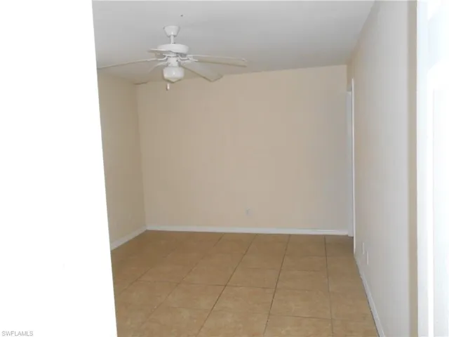 Spare room with a ceiling fan and light tile patterned floors