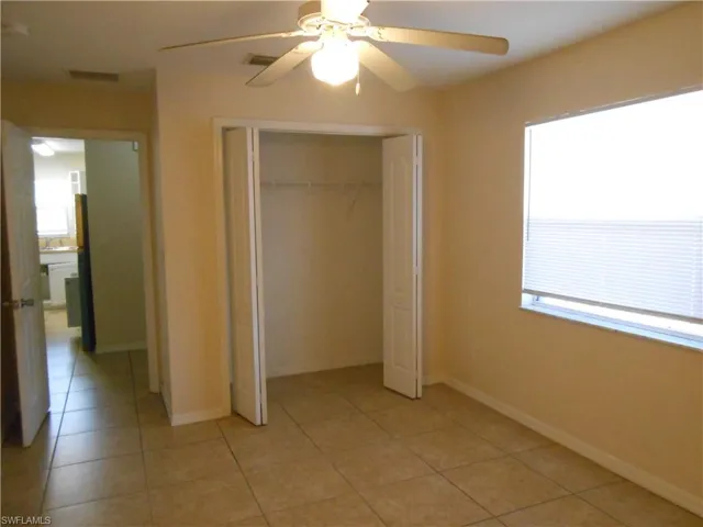 Unfurnished bedroom with a ceiling fan, a closet, and light tile patterned flooring