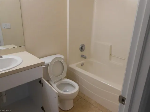 Bathroom featuring vanity, light tile patterned flooring, and shower / bathtub combination