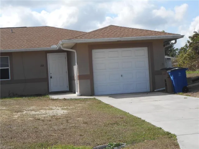 View of front of property with a shingled roof, concrete driveway, an attached garage, and stucco siding