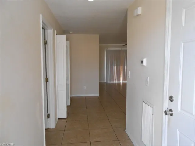 Corridor with light tile patterned floors and baseboards