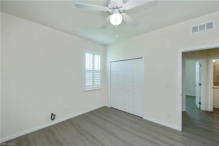Unfurnished bedroom featuring wood finished floors, a closet, and ceiling fan